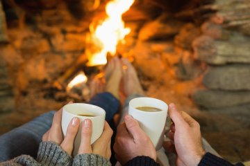 Couple having tea in front of fireplace