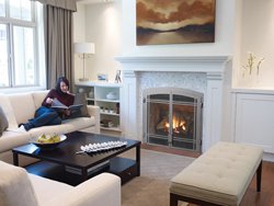 Woman reading book lying near fireplace